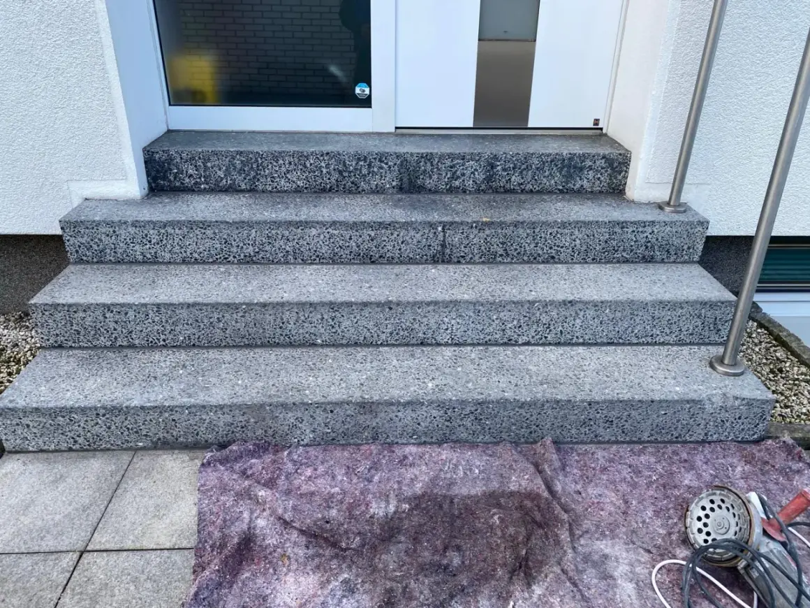 Schritt für Schritt wird die Marmortreppe gereinigt. Ein Schutzvlies liegt bereit, Werkzeug für die Reinigung ist zu sehen.