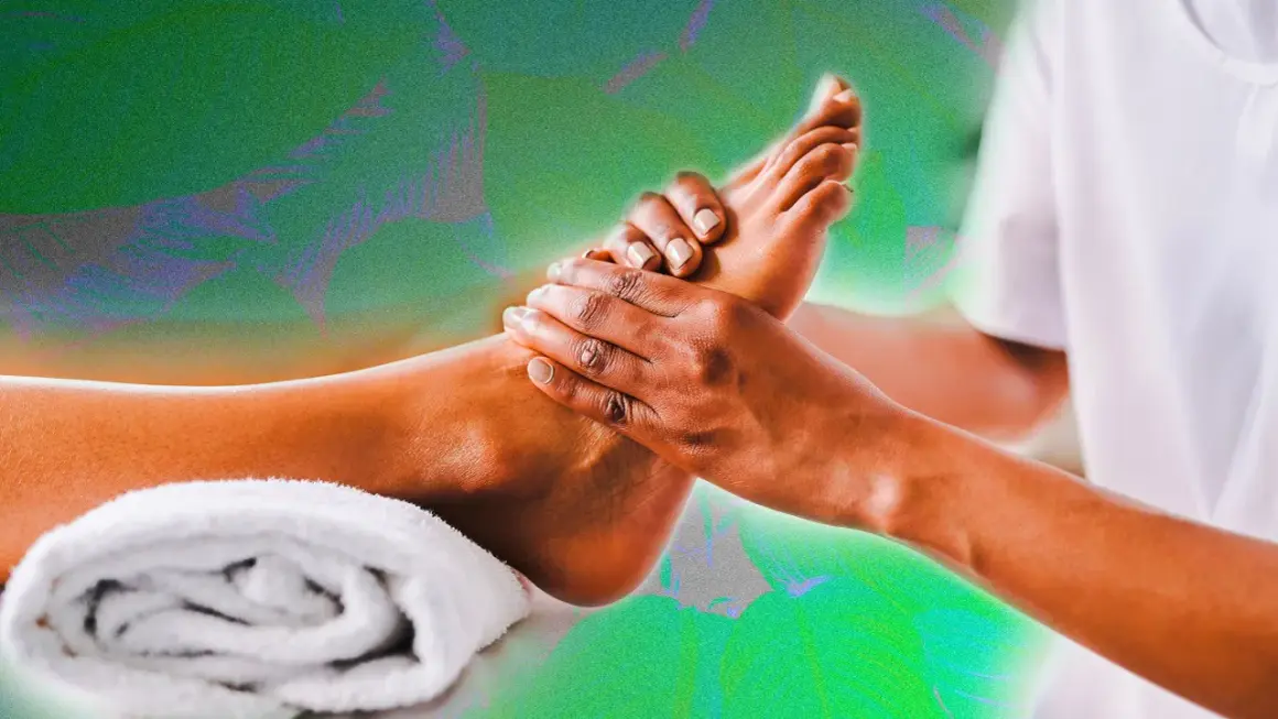 Mains expertes prodiguant un massage pied relaxant, avec une serviette blanche enroulée à proximité.