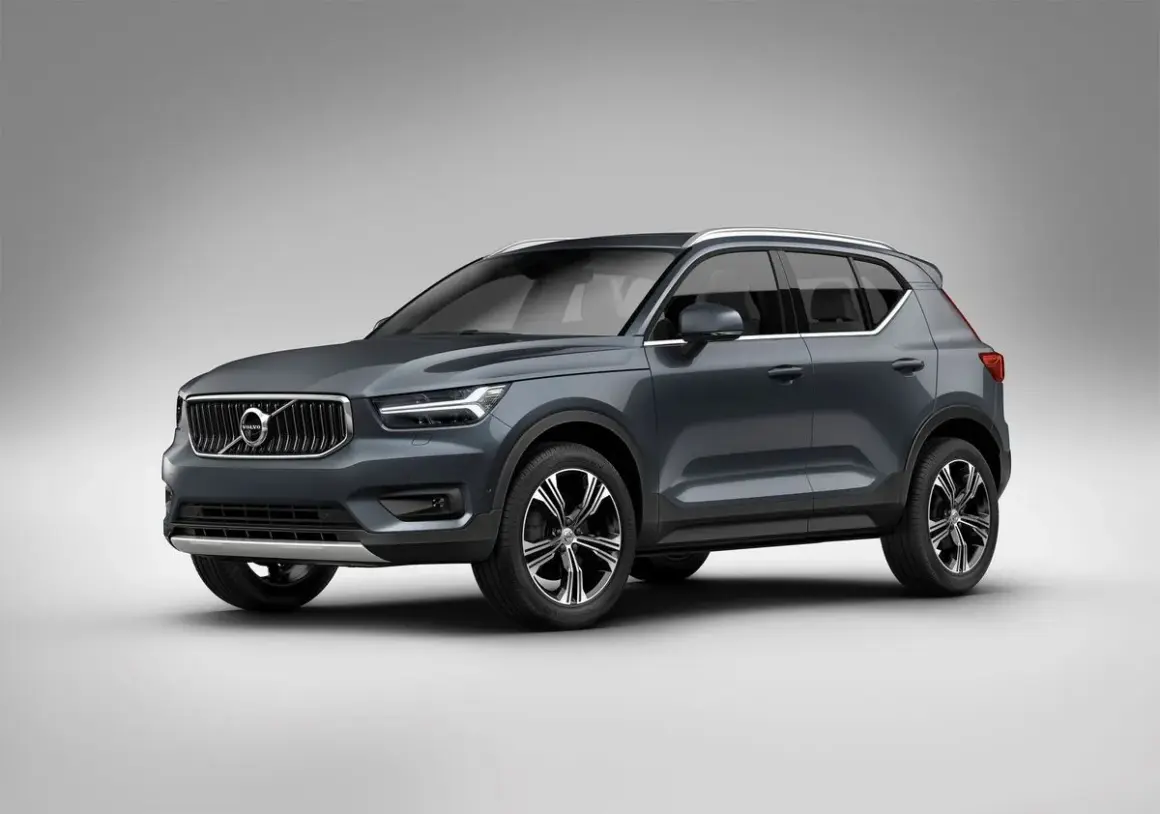 Elegancki, ciemnoszary Volvo XC40 prezentuje się na tle jasnej ściany, gotowy na miejskie wyzwania.