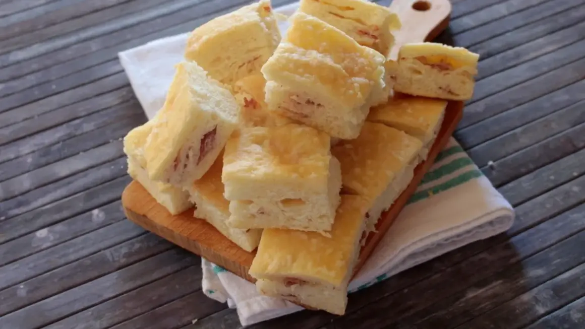 Sfiziose fette di gnocco fritto al forno, con un ripieno di prosciutto, pronte per essere gustate.
