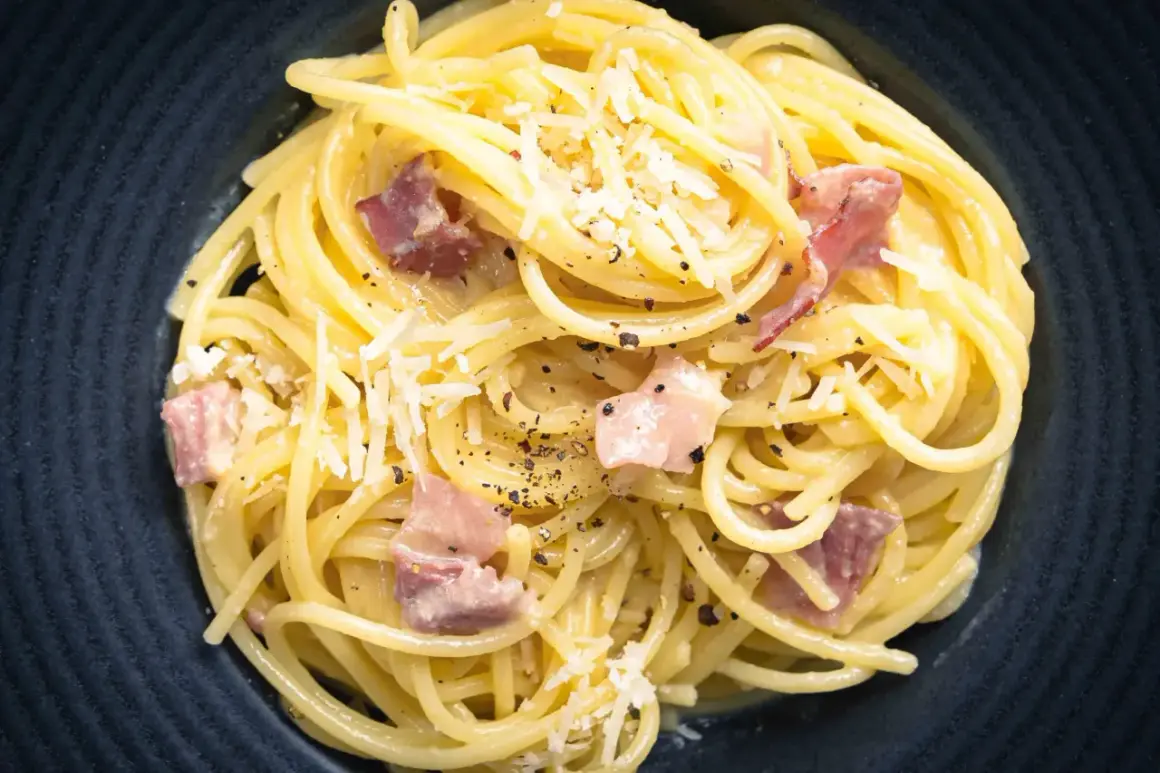 Spaghetti Carbonara mit Speck und Parmesan, ein Gericht, das man leicht perfekt zubereiten kann, wenn man die 10 Fehler beim Pasta kochen vermeidet.