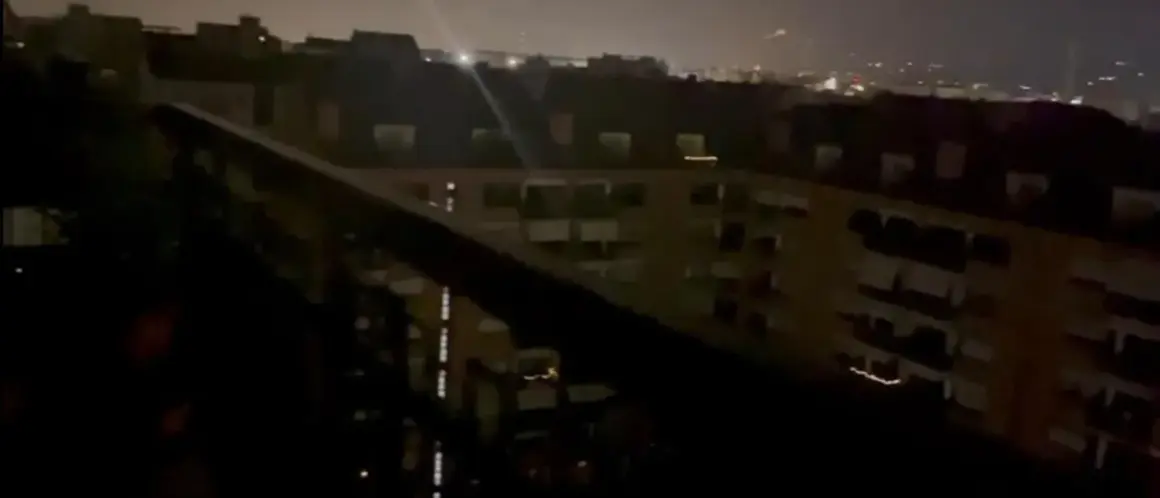 Un panorama notturno di Torino, con luci soffuse che illuminano i palazzi e un cielo velato.
