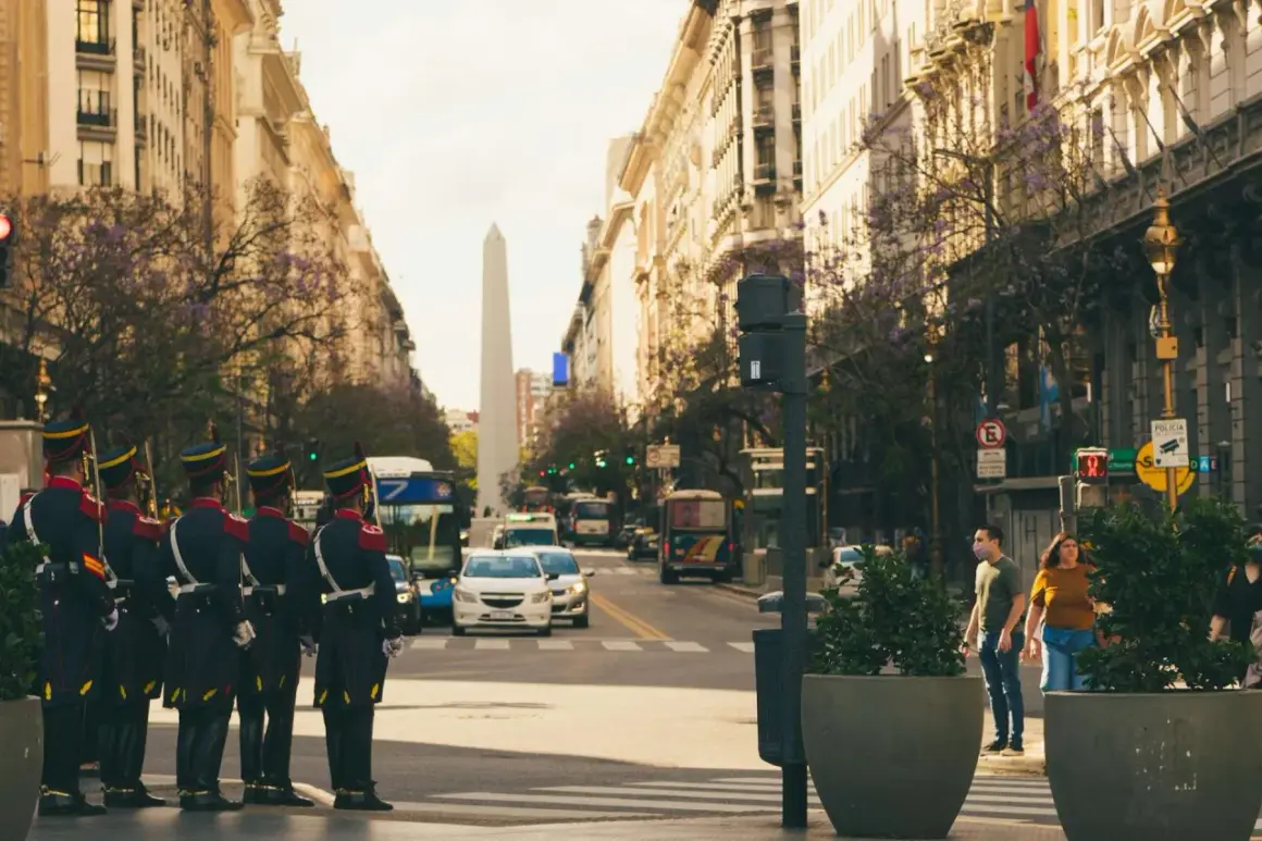 Uliczny patrol w Buenos Aires, Argentyna. Bezpieczeństwo miasta strzeżone przez żołnierzy w historycznych mundurach, na tle obelisku i zabytkowych budynków.