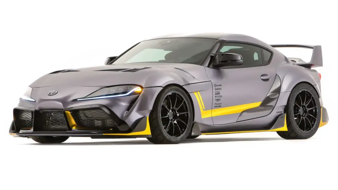Toyota Supra gris con kit aerodinámico y detalles amarillos, un verdadero deportivo con motor BMW.