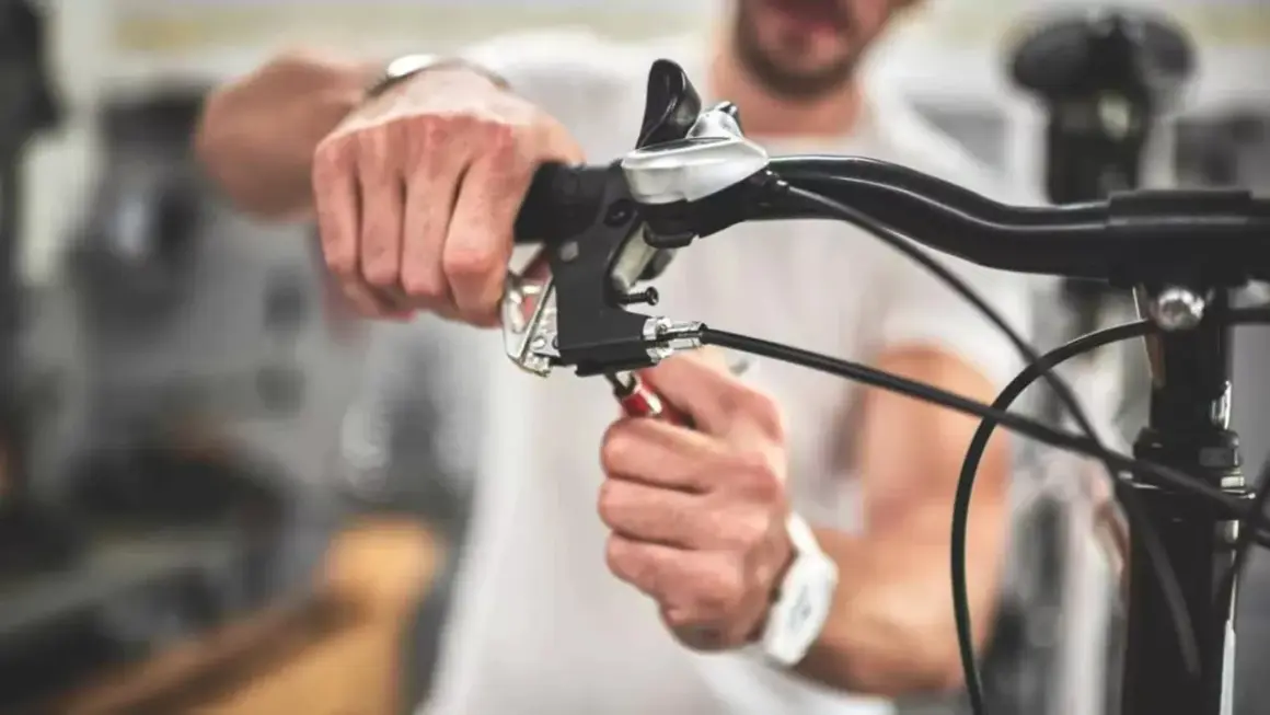 Man stelt de terugtraprem af met een sleutel aan het stuur van een fiets.