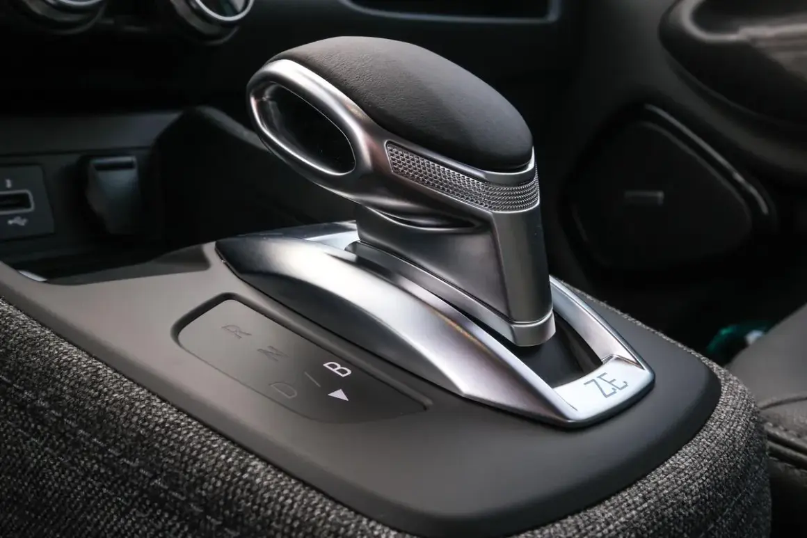 Levier de vitesse d'une b boite auto moderne, avec indicateurs lumineux R, N, D, B. Le design est futuriste et élégant.