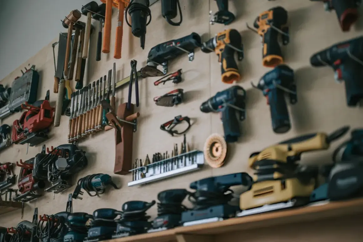 Un mur rempli d'outils pour travailler le bois : perceuses, ponceuses, scies sauteuses, ciseaux, marteaux et autres accessoires essentiels pour tout artisan.