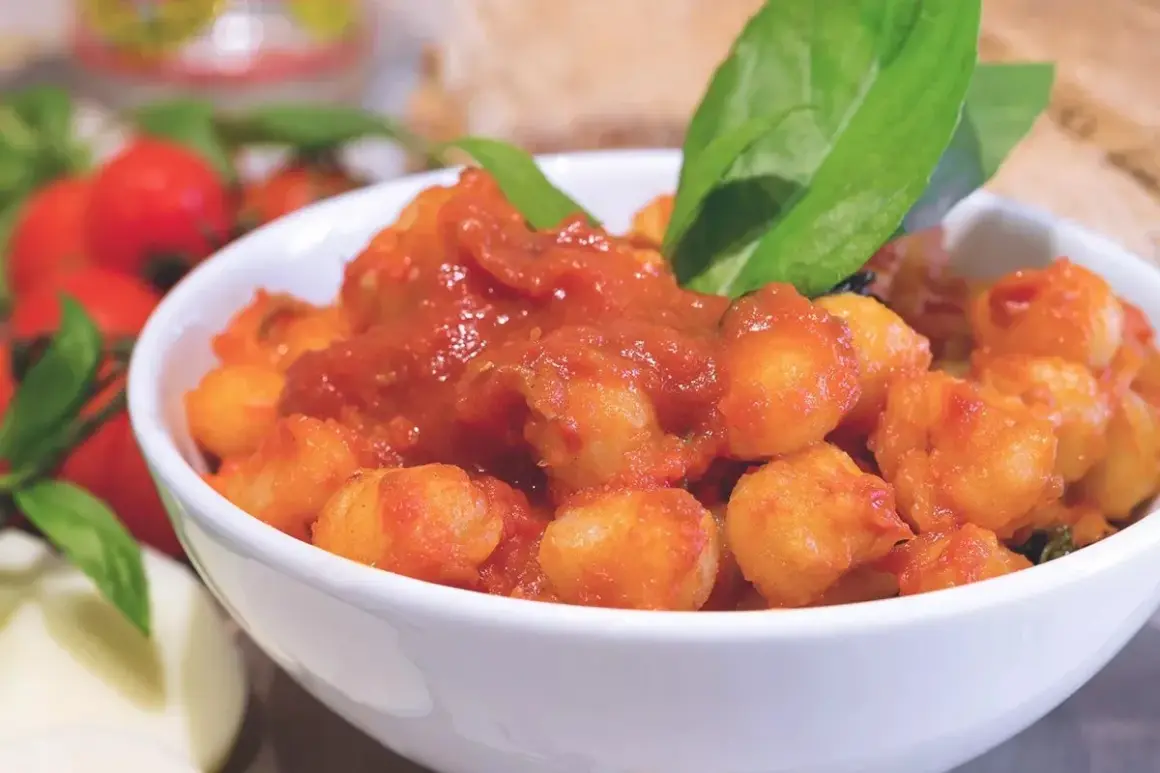 Gnocchi al pomodoro in una ciotola bianca, guarniti con basilico fresco. Un'idea su come condire gli gnocchi per un piatto saporito.