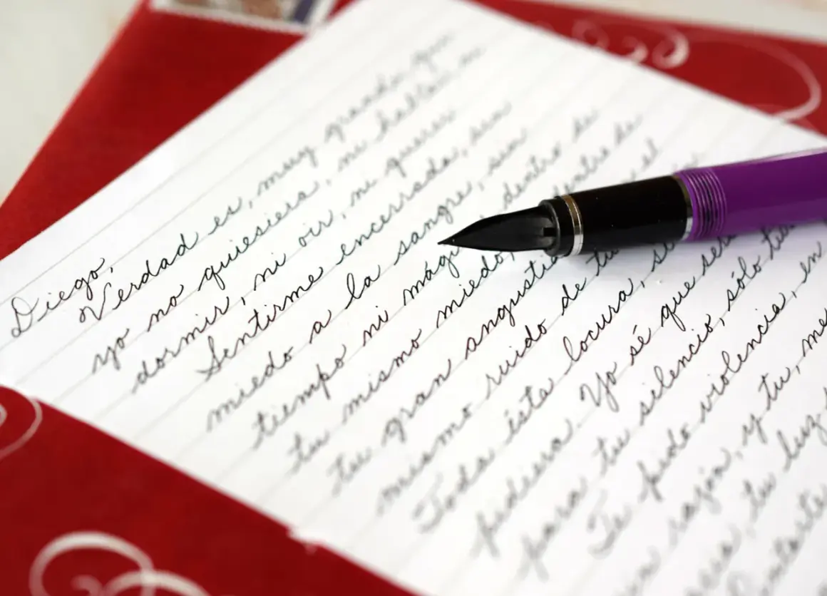 A purple fountain pen rests on a letter written in elegant cursive, demonstrating how to write it in cursive.