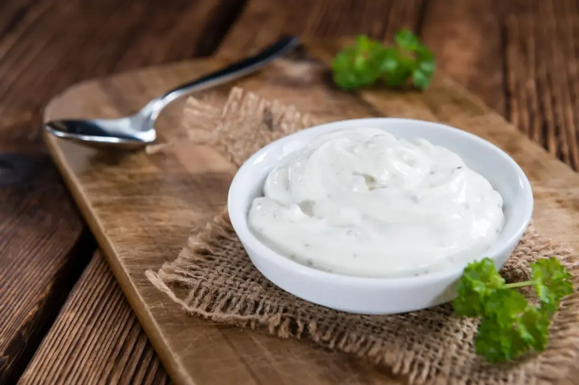 Cremige Sour Cream in einer Schale, bereit zum Dippen. Ein Löffel liegt daneben.