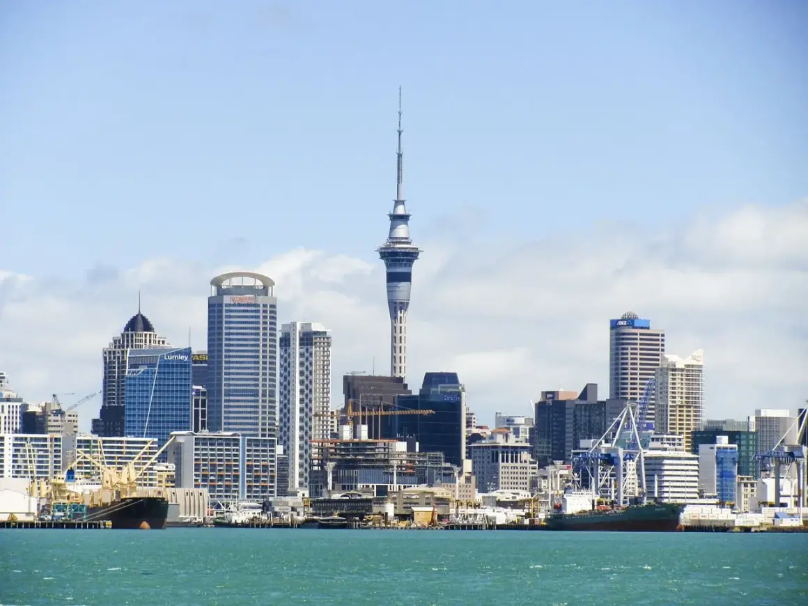 Skyline de Auckland, Nueva Zelanda, con la Sky Tower y barcos en el puerto. ¡Un destino ideal cuando viajar a Nueva Zelanda!