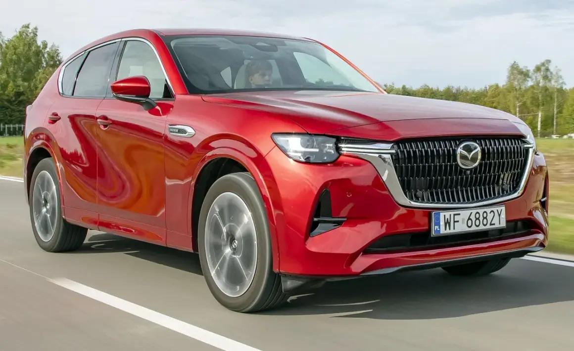 Czerwona Mazda CX-60 na drodze, podczas testu. Kierowca w kabinie.