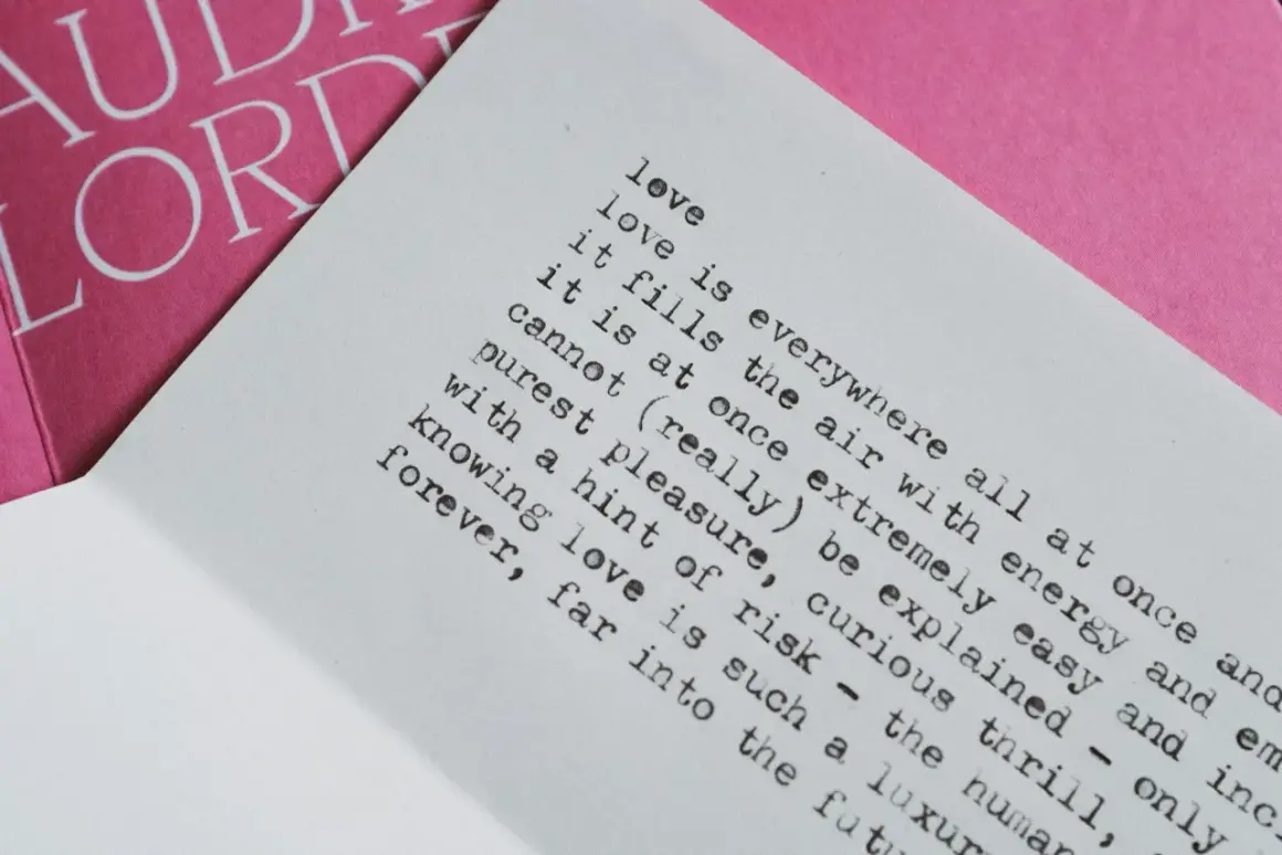 Piękny wiersz o miłości i tęsknocie, z tekstem "love is everywhere" na białej kartce, obok różowej okładki z napisem "AUDRE LORDE".