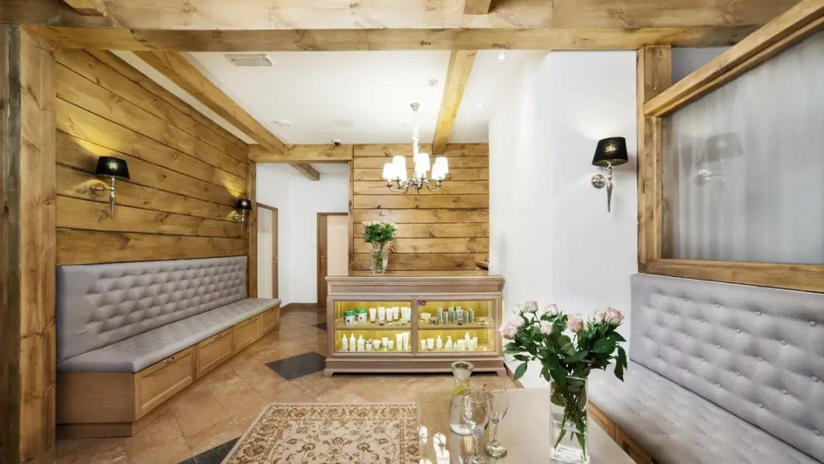 Przytulne wnętrze salonu spa w Białymstoku i okolicach. Drewniane ściany, wygodne ławy i ekspozycja kosmetyków tworzą atmosferę relaksu.