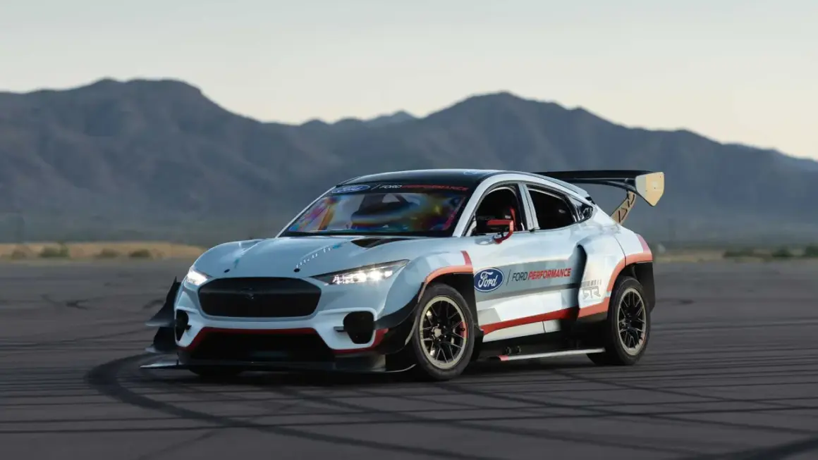 Wyścigowy Ford Mustang Mach-E 1400 z ogromnym skrzydłem i agresywnym bodykitem na torze.