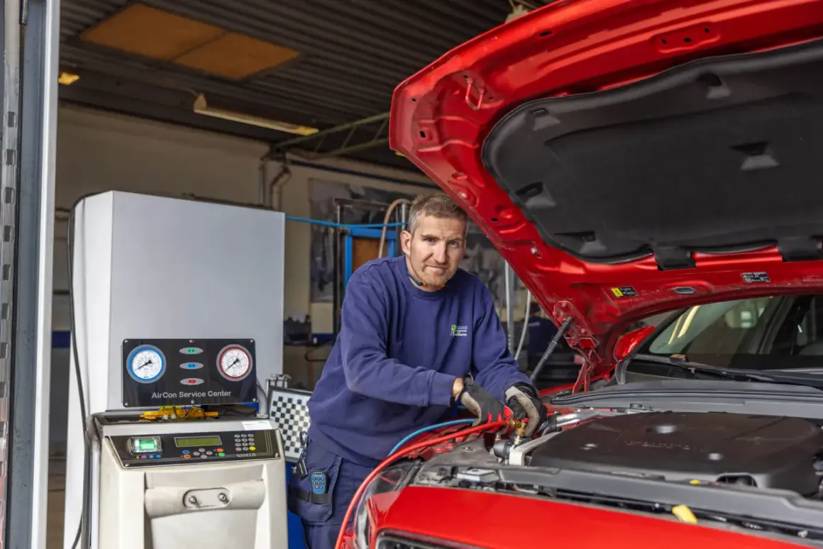 Mekaniker arbetar med en bilens AC-system, som visar hur fungerar en ac i bilen.