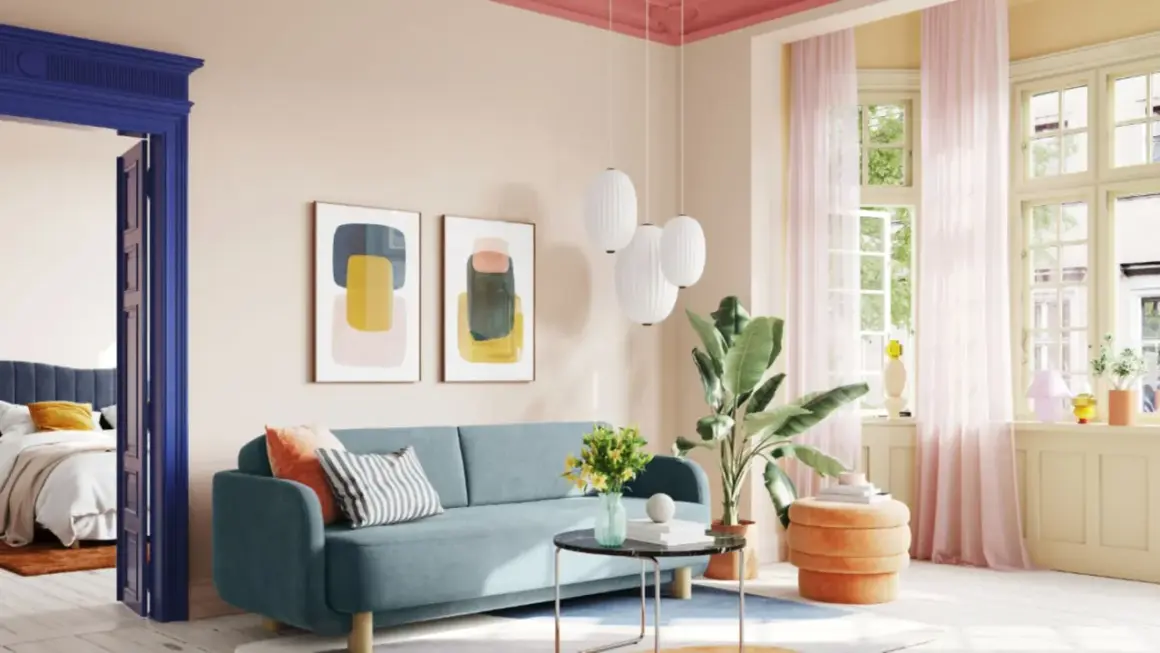 Ein Wohnzimmer mit blauem Sofa, Kunstwerken und einem orangefarbenen Hocker. Die Decke ist in einem kräftigen Pink gestrichen, was einen schönen Kontrast zur hellen Wandfarbe bildet.