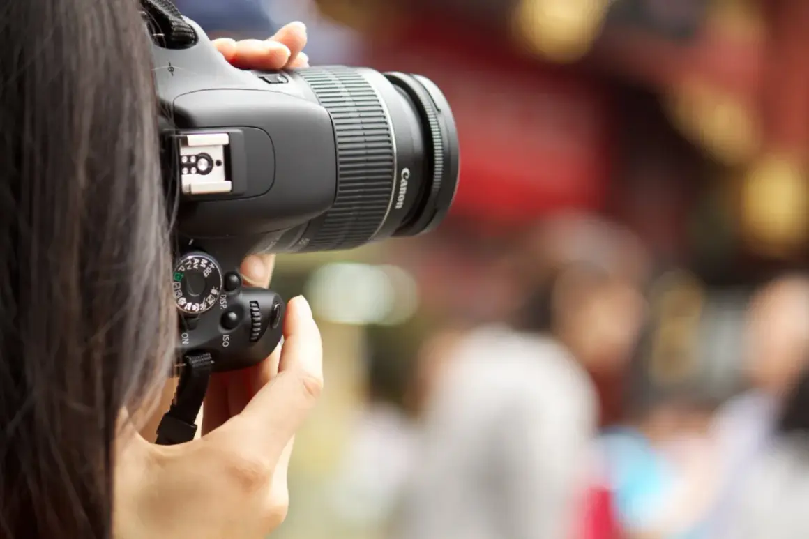A person's hands hold a Canon digital camera, ready to capture a moment. This image is a great visual for anyone learning how to buy a digital camera.