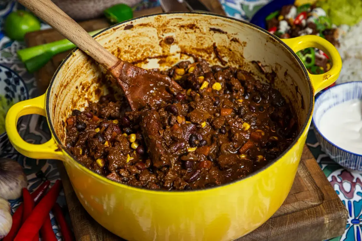 En stor gul gryta fylld med mustig chili sin carne, redo att serveras. Perfekt för ett värmande recept.