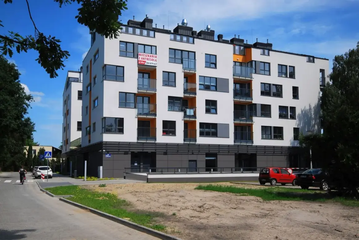 Nowoczesne mieszkania Grodzisk Mazowiecki z antresolą czekają na swoich lokatorów. Jasna elewacja, balkony i dużo światła.