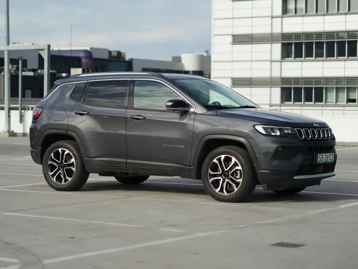 Szary Jeep Compass na parkingu. Zastanawiasz się nad jego spalaniem? Ten model oferuje dobre osiągi i komfort jazdy.