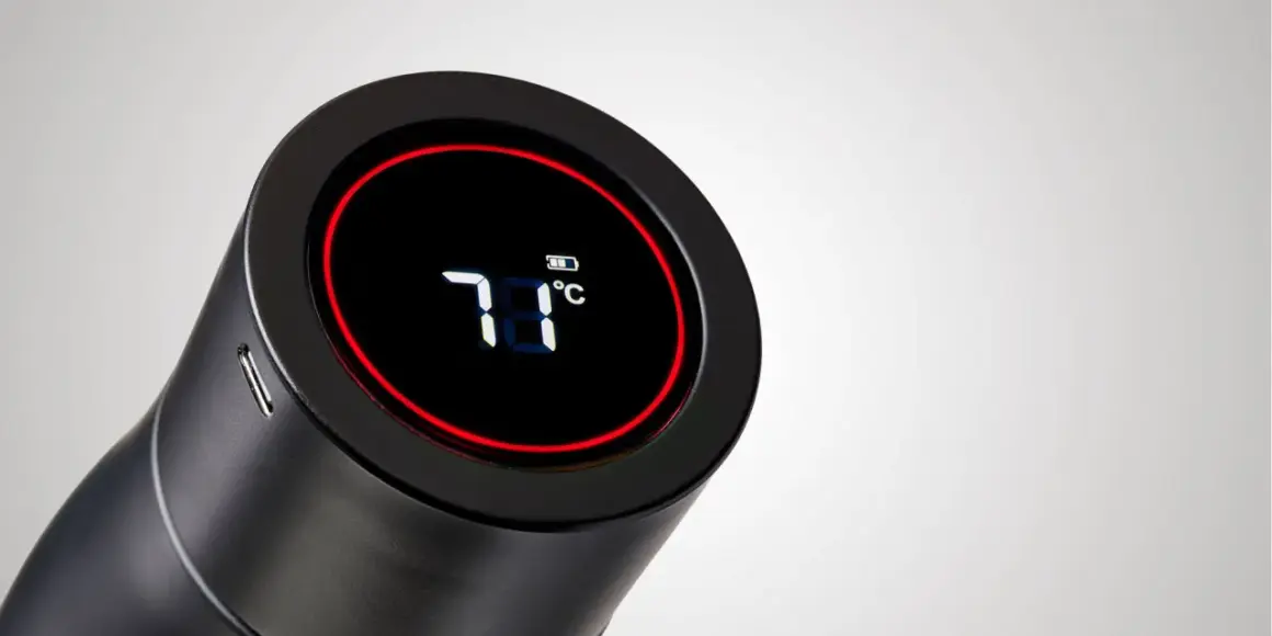 Schwarze Trinkflasche mit digitaler Anzeige (71°C) und Akku-Symbol. Eine smarte Trinkflasche mit Erinnerungsfunktion, die die Temperatur anzeigt.