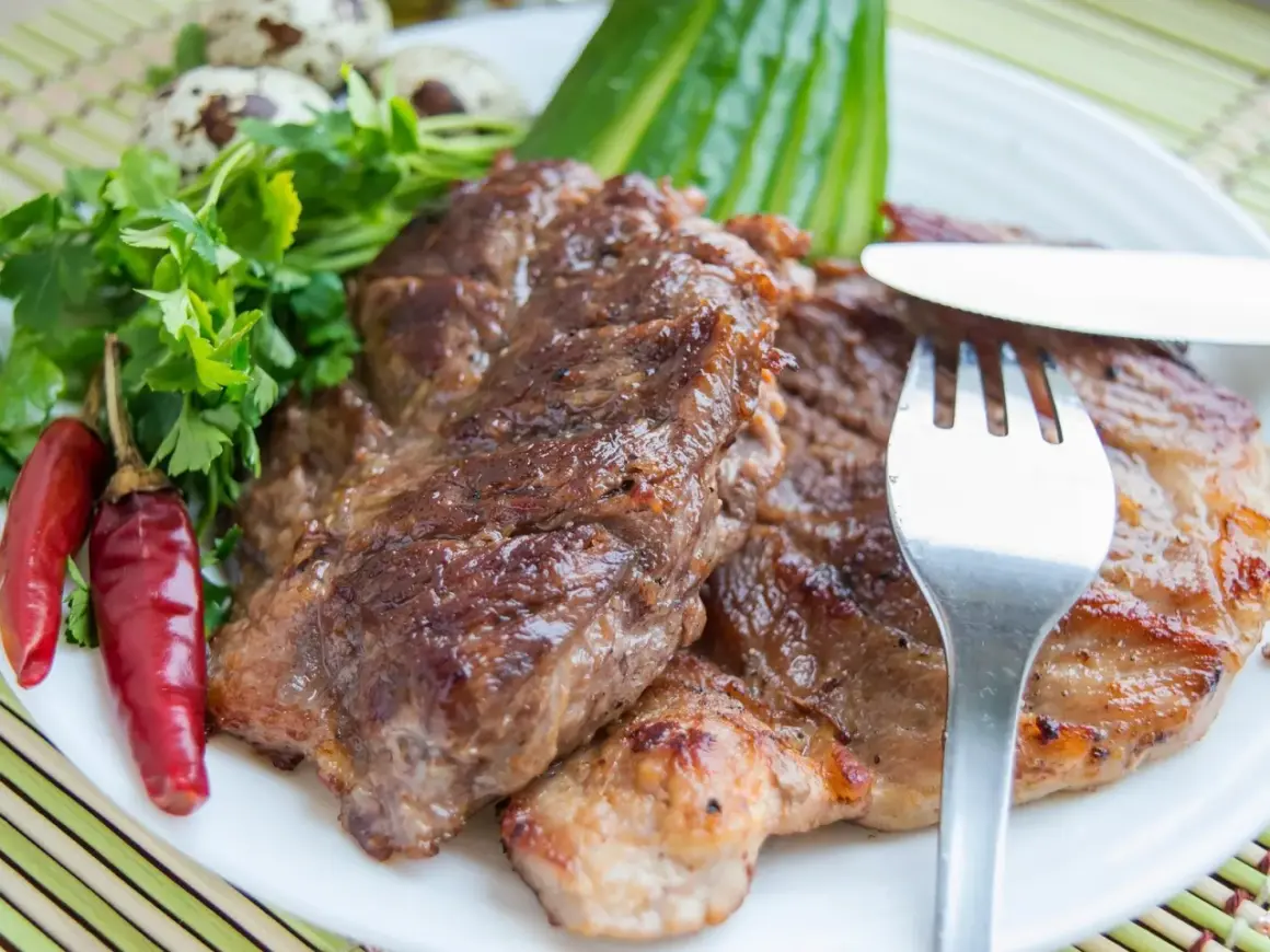 Saftiges Schweinesteak, mariniert und perfekt gegrillt, serviert mit Petersilie, Chilischoten und Wachteleiern. Ein Genuss für Fleischliebhaber.