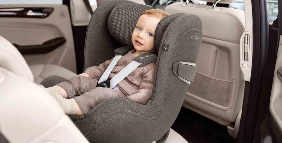 Kleines Kind im Kindersitz, das sich auf die Frage konzentriert: ab wann darf Baby in Fahrtrichtung sitzen?