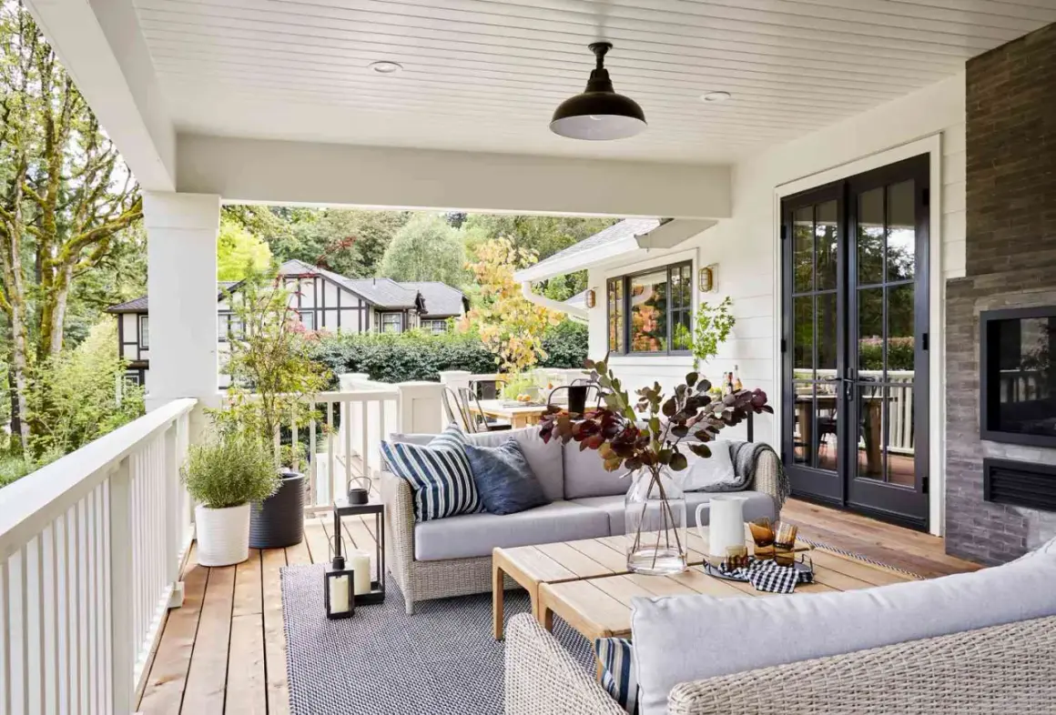 Cozy backyard makeover with a covered porch, outdoor sofa, coffee table, and fireplace.