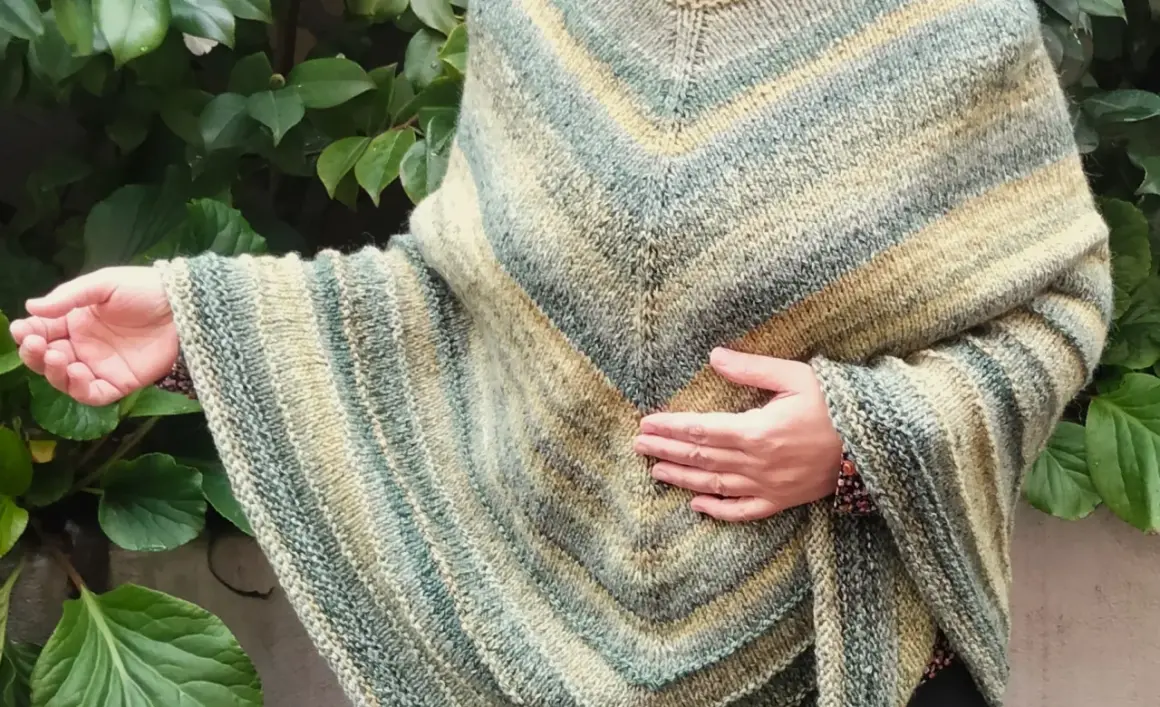 Poncho ai ferri schema facile, con righe sfumate in verde e beige. Un capo comodo e stiloso, perfetto per ogni occasione.