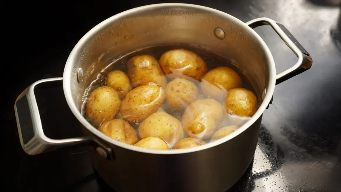 Ein Topf mit vielen Kartoffeln, die in Wasser kochen. Sind Kartoffeln gesund? Ja, sie sind eine gute Quelle für Vitamine und Mineralstoffe.