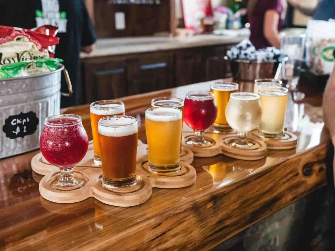 Bierverkostung mit verschiedenen Sorten in Gläsern auf Holztabletts. Perfekte trinktemperatur für jedes Bier.
