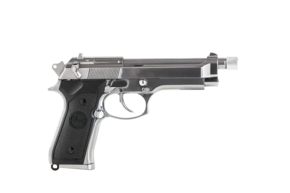 Pistola airsoft plateada con silenciador, lista para la acción.