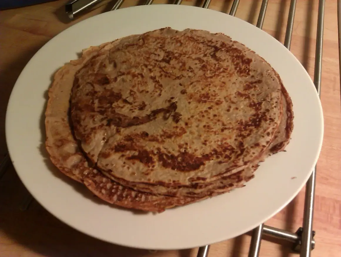 En hög med tunna pannkakor på en vit tallrik. Perfekt protein frukost för att gå ner i vikt.