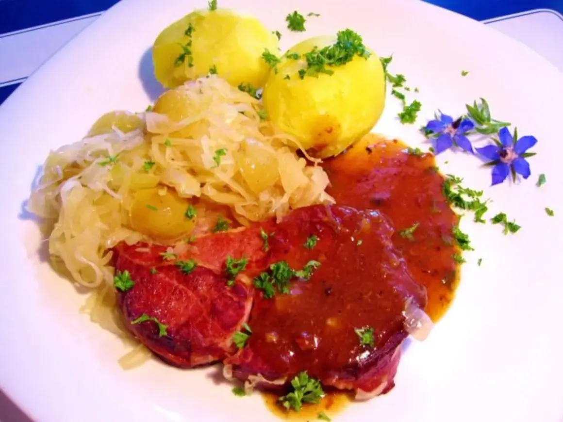 Gekochte Rippchen zubereiten: Herzhaftes Gericht mit deftigen Rippchen, Sauerkraut und Kartoffeln, garniert mit Petersilie und blauen Blüten.