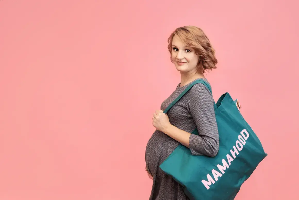 Przyszła mama z torbą "Mamahood" na ramię, gotowa na poród. Idealna torba do szpitala na operację.