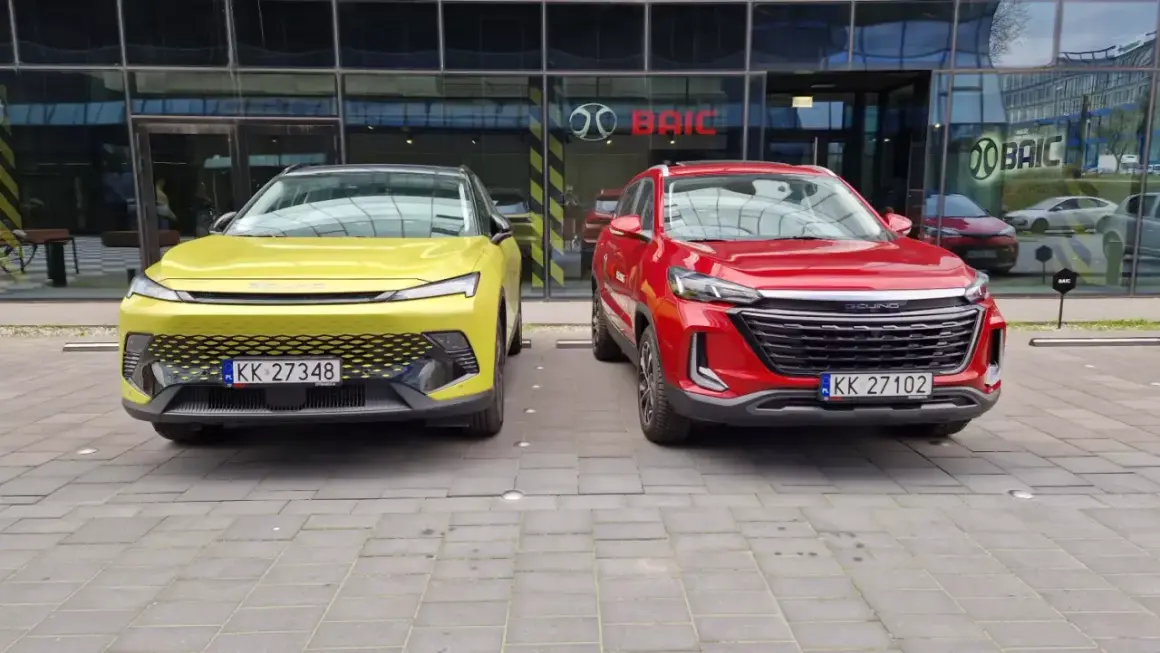Dwa nowe chińskie samochody, żółty i czerwony, zaparkowane przed salonem BAIC w Europie.