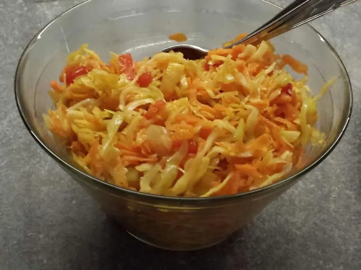 En skål med kålsallad, morötter och tomatbitar. Perfekt som tillbehör till middagen, en riktig 3 veckors sallad!