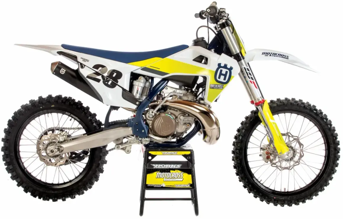 Motocykl Husqvarna 250 Enduro z numerem 28, biało-żółty, na czarnym stojaku.