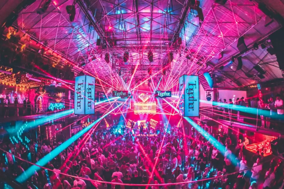 Niesamowite ibiza imprezy w klubie z laserami i tłumem bawiącym się w rytm muzyki.