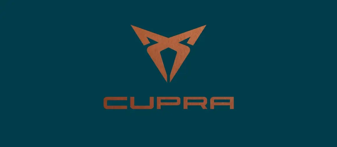 Miedziane logo Cupra na granatowym tle. Symbolizuje moc i dynamikę marki.
