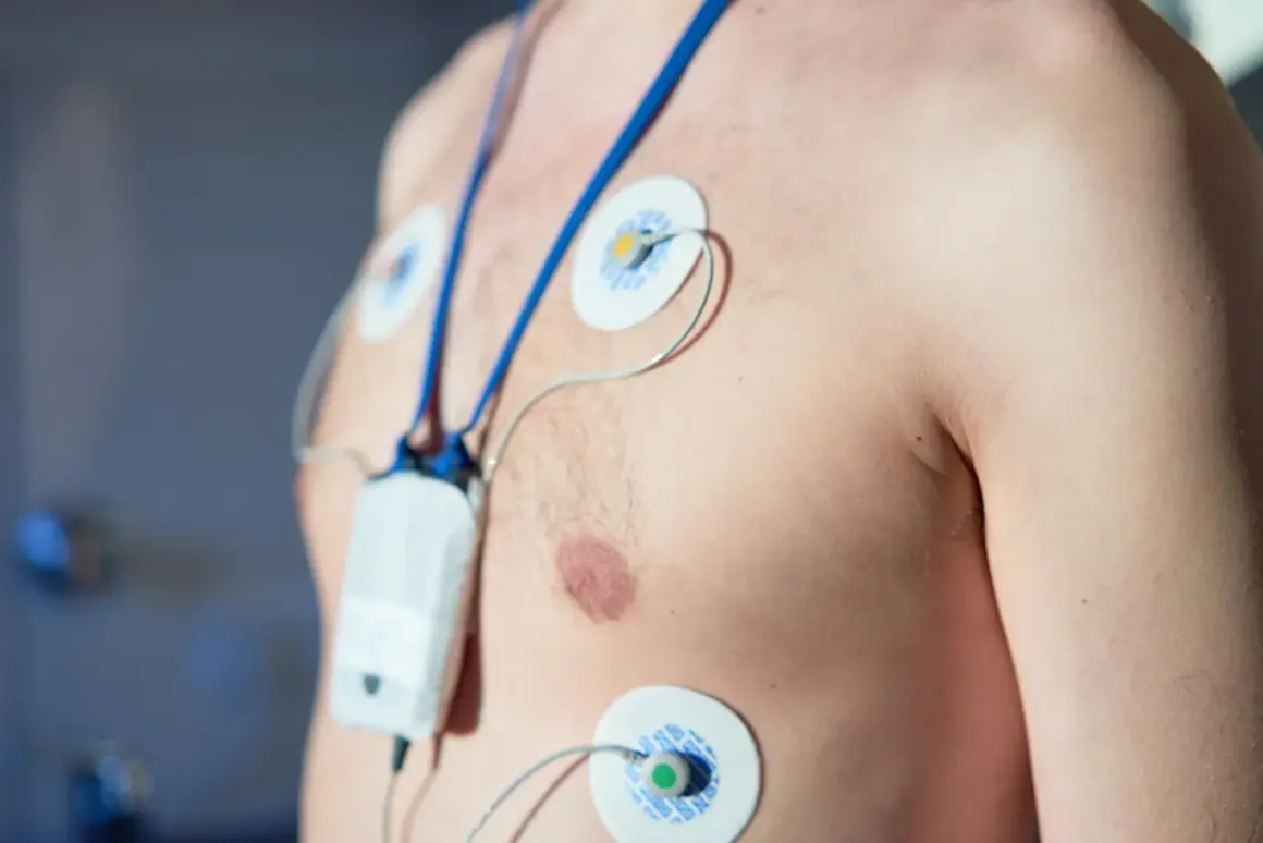 Mężczyzna z elektrodami EKG na klatce piersiowej i podłączonym urządzeniem. To badanie holterowskie, które pomaga ocenić pracę serca.