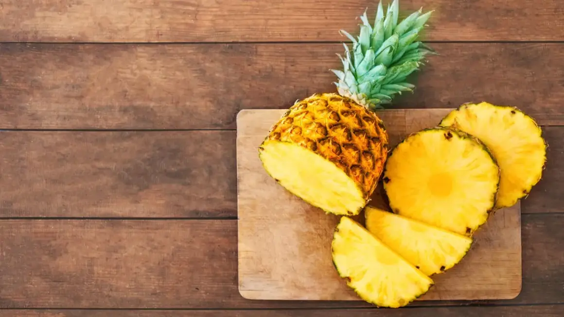 Saftige Ananas, frisch aufgeschnitten, liegt auf einem Holzbrett. Eine gesunde Wahl, die an den Geschmack von Ananas aus der Dose erinnert.