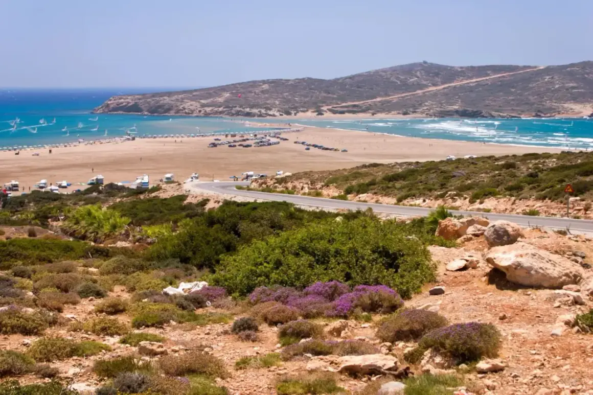 Piękna plaża na Rodos, idealne miejsce na windsurfing. W oddali widać góry, a droga prowadzi do tego rajskiego zakątka. Rodos miasto atrakcje to nie tylko zabytki, ale i takie widoki!