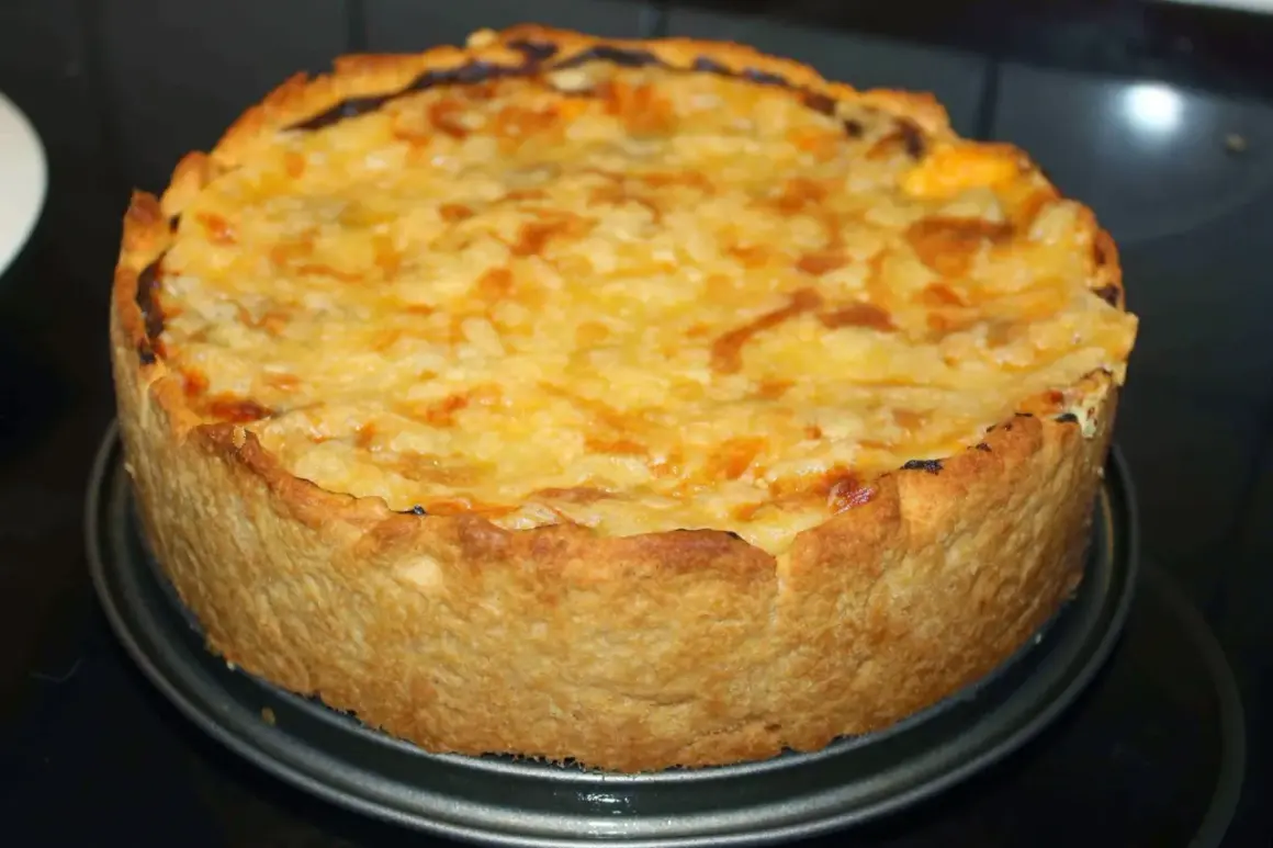 En gyllene, nybakad kycklingpaj med ostigt täcke, redo att avnjutas. En perfekt leilas kycklingpaj!