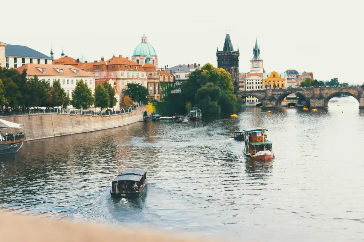 Praga, Czechy. Widok na Wełtawę z łodziami i Mostem Karola. Ceny w Czechach mogą być zaskakująco przystępne, zwłaszcza poza sezonem.