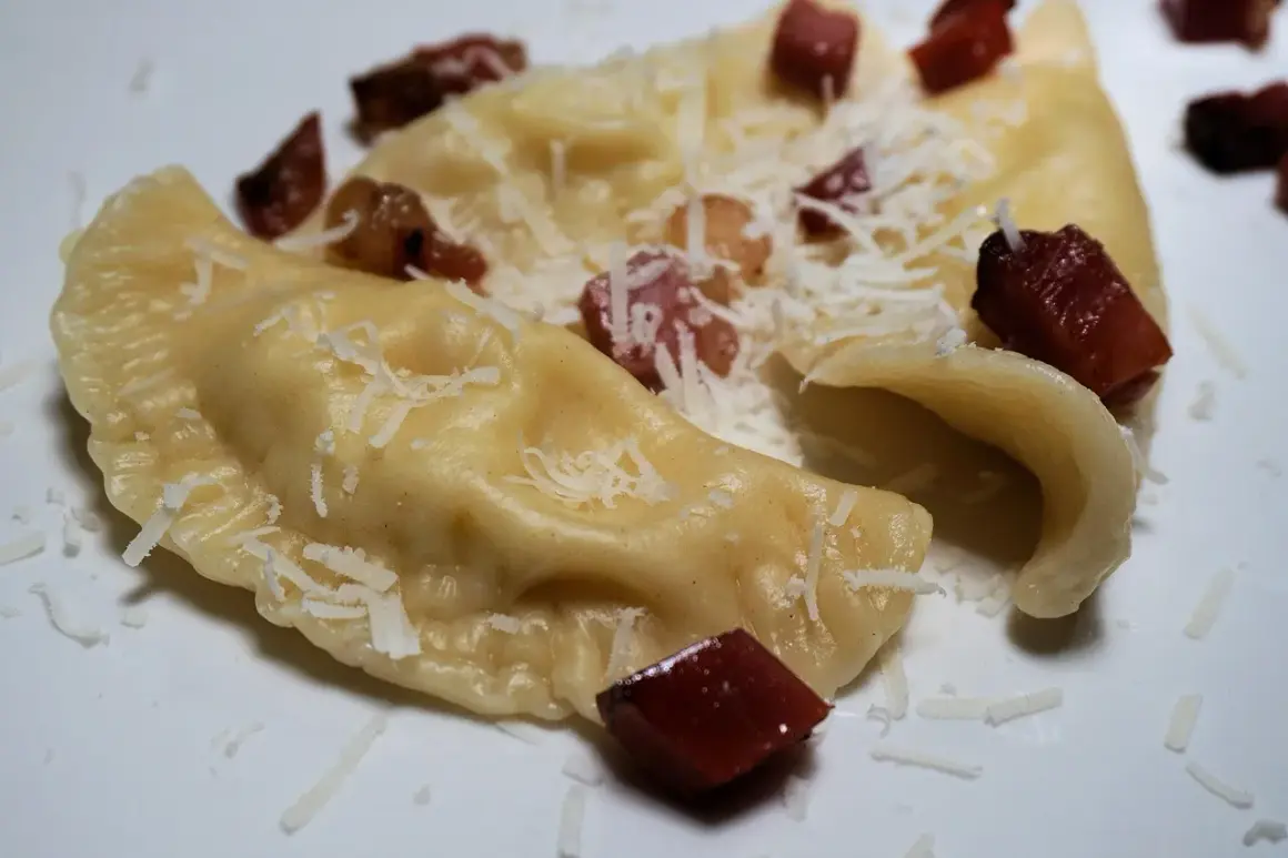 Pierogi, en klassisk polsk mat, serveras med riven ost och tärnat fläsk.