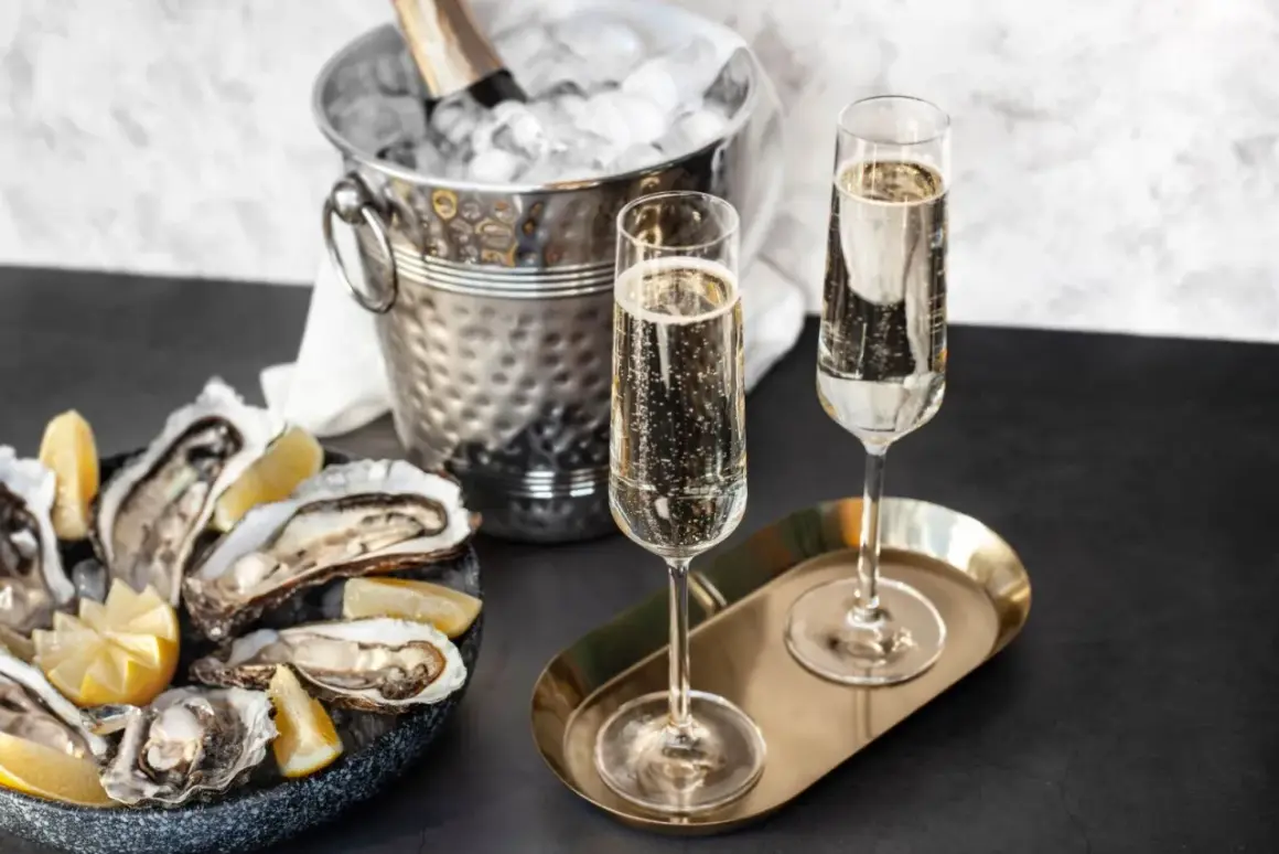 Austern mit Zitrone, Champagnergläser und Eis-Eimer mit Flasche.