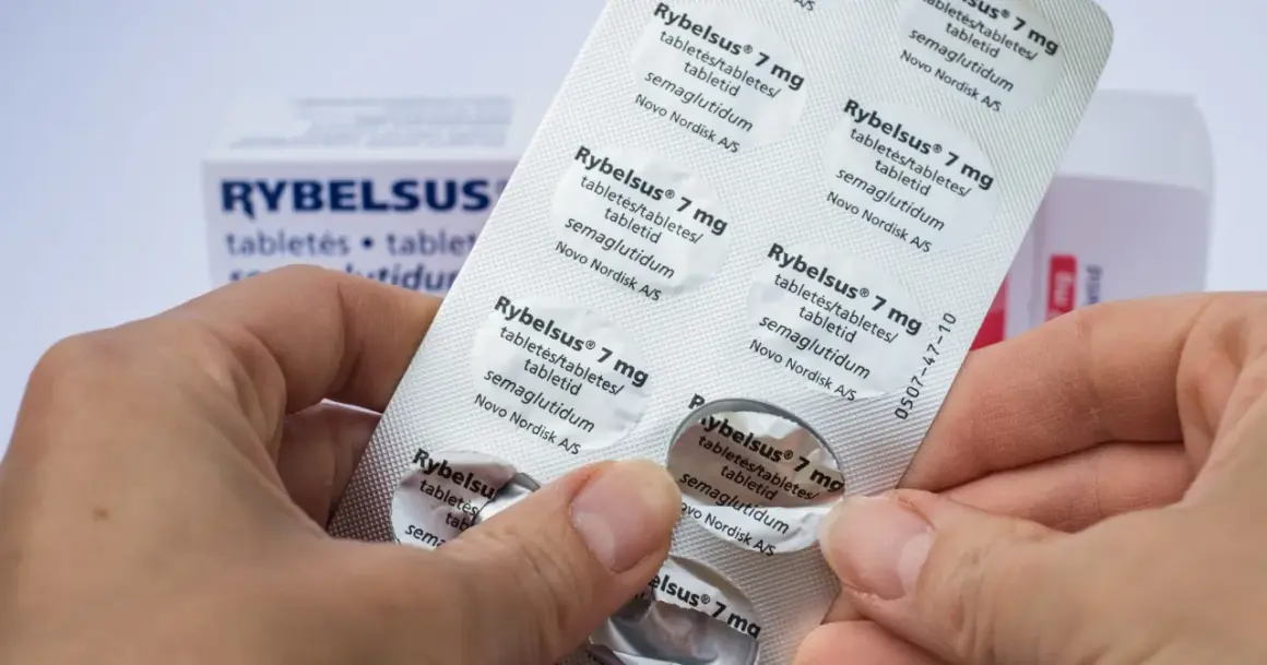 Dłonie trzymają opakowanie leku Rybelsus 7 mg, zawierającego tabletki z semaglutydem.