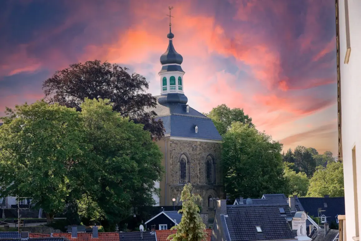 Kirchturm in Solingen Altstadt vor dramatischem Abendhimmel.